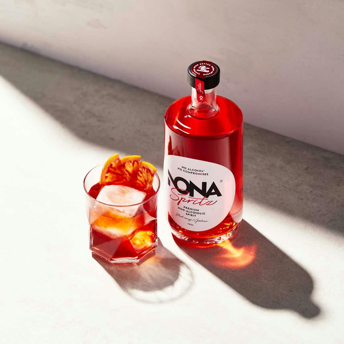 Bottle of non-alcoholic spritz by Nona and glass with non-alcoholic spritz